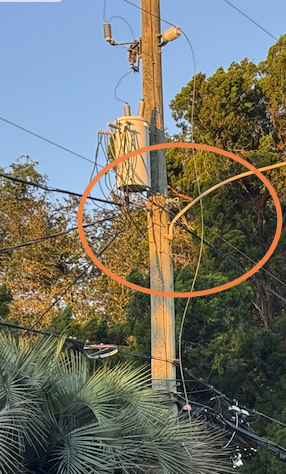 Broken high voltage power line wire touching cable TV and phone lines.